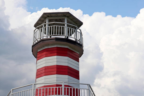 istock Lighthouse tower against blue sky and white clouds 1251000392