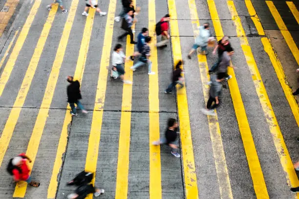 Photo of people walking, on pedestrian crossing steet - motion blur