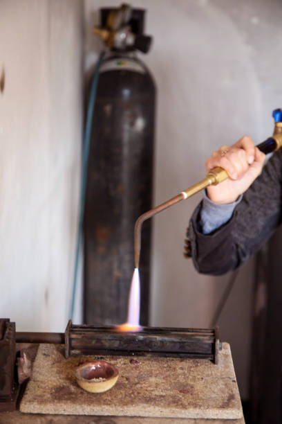 istock A Jewelry designer melting down silver pellets to shape into a ring. 1251003003