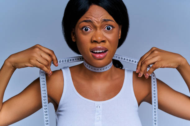 istock Scared woman wrapped a flexible meter around her neck and screaming. Diet concept 1251003089