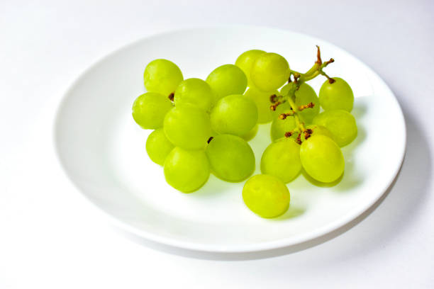 istock Green delicious ripe grapes on a white plate 1251003127