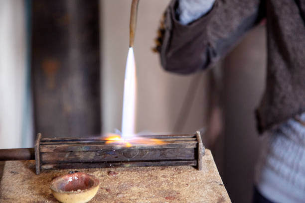 istock A Jewelry designer melting down silver pellets to shape into a ring. 1251003180