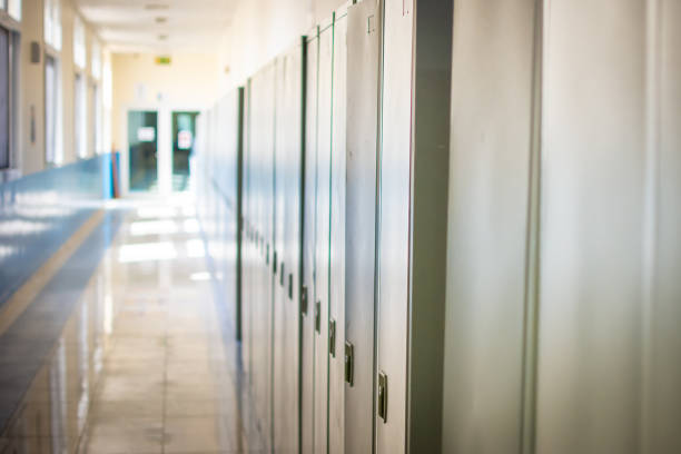 Empty hallway corridor of a high school or college closed during COVID-19 (Coronavirus). Lockers blurred into lonely hallway. stock photo