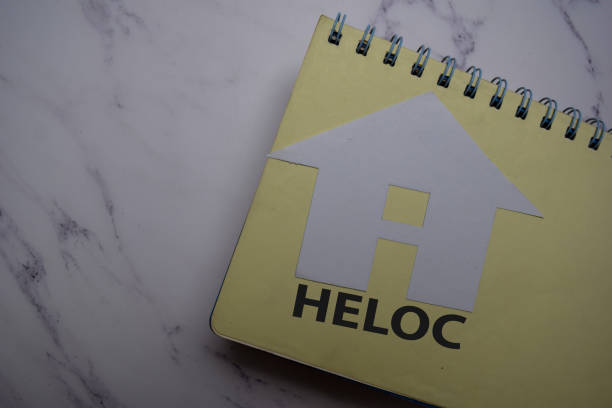 heloc écrire sur la note collante et la maison faite à partir de papier isolé sur office desk. - stick note pad yellow sticky photos et images de collection