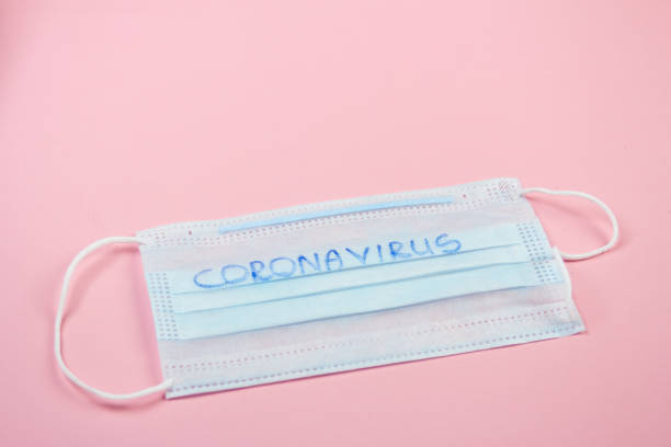 istock Medical disposable mask on a pink background with copy space 1251006381