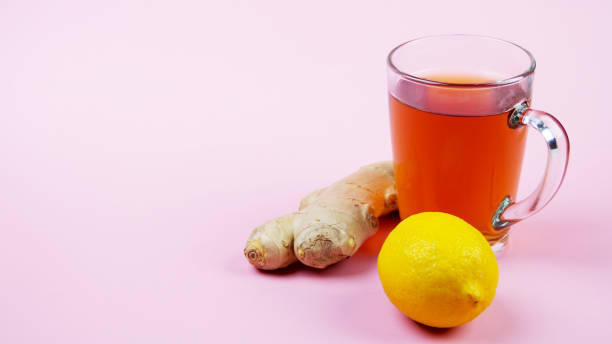 istock Cup of ginger tea with lemon on a pink background 1251006390