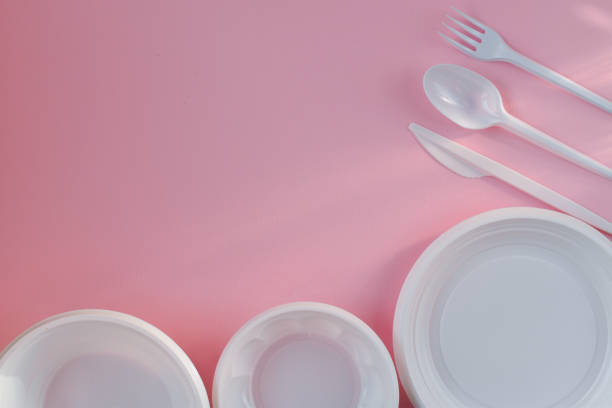 istock Plastic white dishes on a pink background on the right and bottom 1251007782