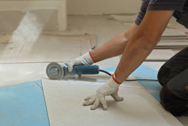 Worker Cutting ceramic tiles with circular saw close up