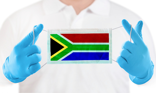 Holding protective Mask and medical gloves with the a flag of South Africa.\nNikon, June 15,2020  Kuwait