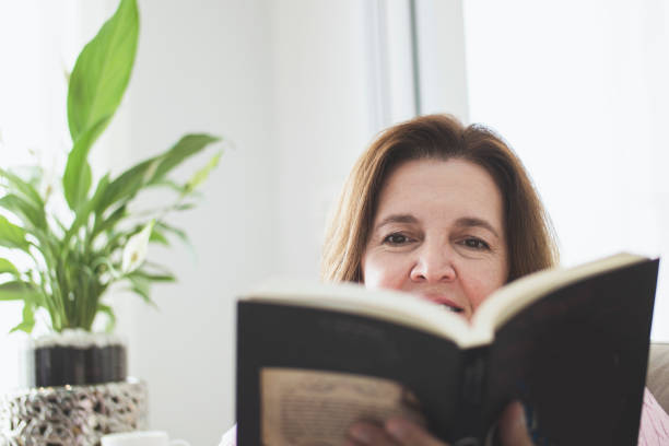 istock Woman at home reading an analog book. 1251012576