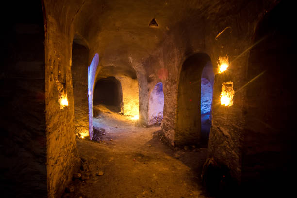 istock Dark abandoned underground chalky cave temple illuminated by candles 1251016432