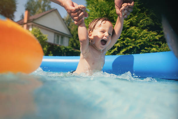 istock Little boy and his father having fun in pool at back yard 1251018464