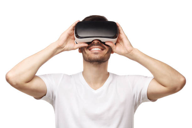 istock Young smiling man wearing tshirt and virtual reality headset or VR glasses, playing video game, isolated on white background 1251024361