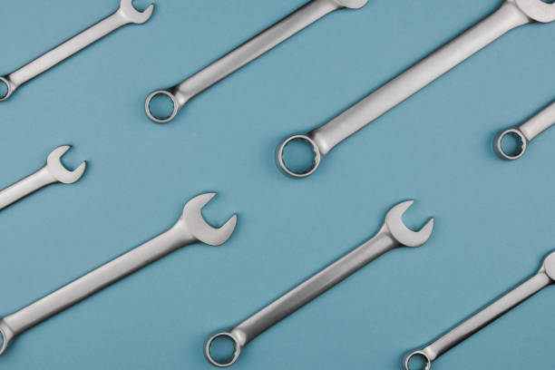 istock Set chrome spanner keys lying side by side on blue background. Flat lay, top view, minimal composition 1251027173