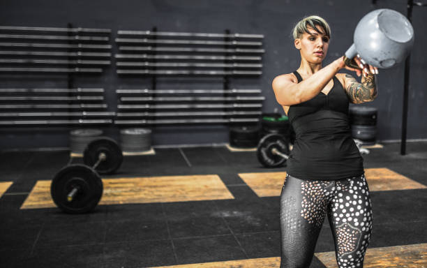 istock woman doing kettlebell in the gym 1251027315