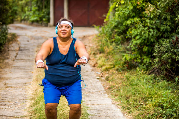 Overweight man warming up before jogging on the street