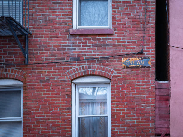 istock Historic red brick building with windows and rusty One Way sign on the wall 1251029826