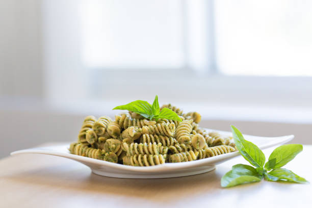 pasta with pesto sauce in close-up in slow motion