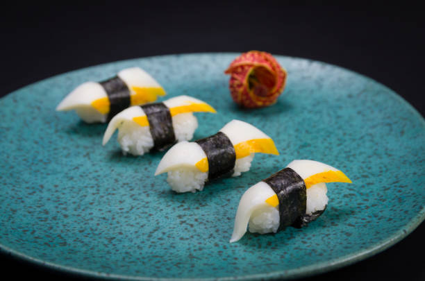 sushi, cocina tradicional japonesa. delicioso sushi hadock tako sobre plato decorado, fondo negro. - niguiri sushi fotografías e imágenes de stock