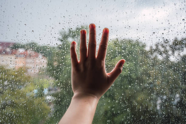 istock Hand on the window with a rainy day 1251039048