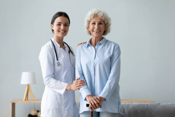 istock Old patient with walking stick and young caring nurse portrait 1251044165