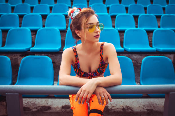 istock Stylish female athlete during break on stadium 1251044457
