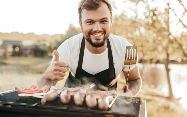 istock Happy man grilling sausages on brazier 1251044487