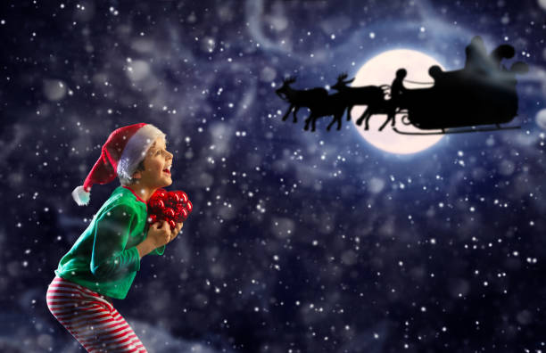 istock Exited boy and Santa Claus sledge over the moon 1251044535