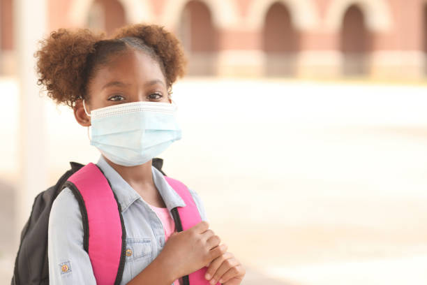 African descent, girl on school campus. Mask for COVID-19. Back to school. African descent girl on school campus. She wears a mask for COVID-19, Coronavirus protection. schoolyard photos stock pictures, royalty-free photos & images