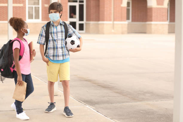 istock Student friends walk to class wearing masks for COVID-19. 1251048646