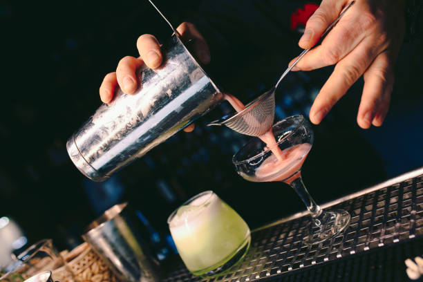 istock Bartender pouring using strainer White healthy Cocktail drink on a bar counter . Professional view . Trendy stylish alcoholic drink .  Design people and luxury concept service barman in nightclub 1251048815