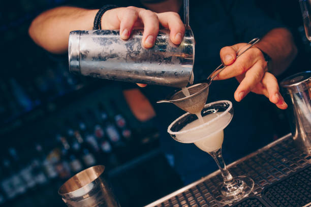 istock Bartender pouring using strainer White healthy Cocktail drink on a bar counter . Professional view . Trendy stylish alcoholic drink .  Design people and luxury concept service barman in nightclub 1251048856