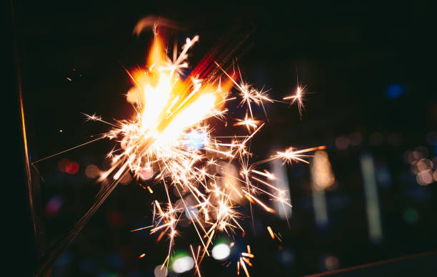 istock Hand holding sparkler.Abstract and brightly colorful firework in the celebration and anniversary festival. Merry Christmas and New year party  flowers candles background 1251049503