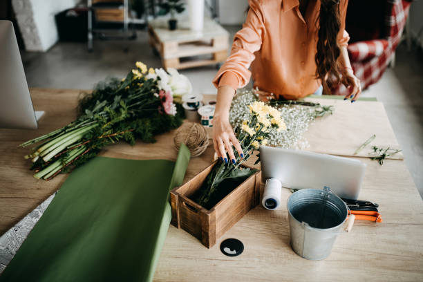 istock Woman arranging flowers at home 1251052790