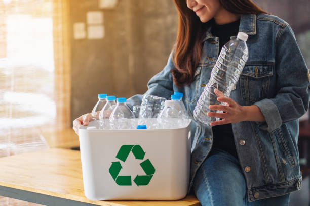 istock A woman collecting and separating recyclable garbage plastic bottles into a trash bin 1251054867
