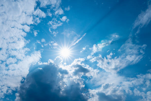 istock blue sky with clouds and sun shines with sunbeams 1251057546