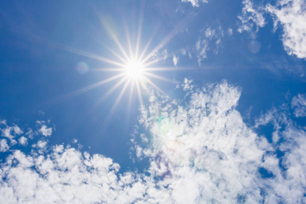 istock sun on blue sky with sunbeams and clouds in the day 1251057553