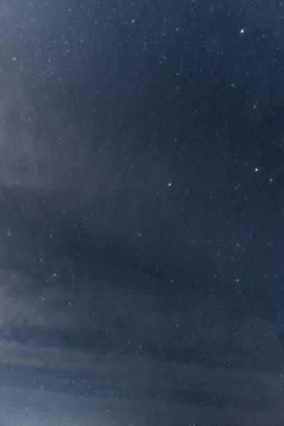 istock Real Night Sky Stars. Natural Starry Sky With Some Clouds Background Backdrop 1251064942