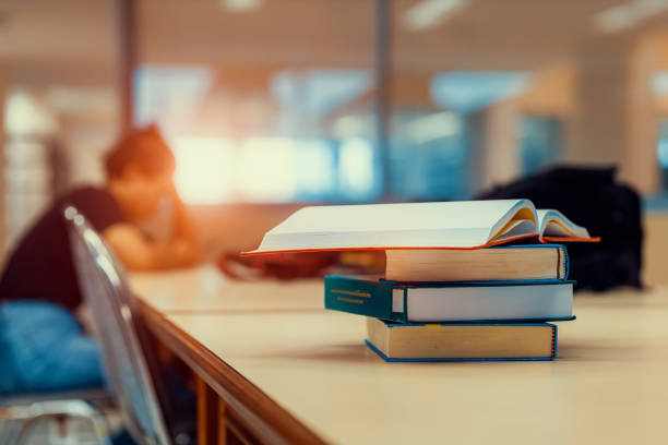 istock Open book on stack of books in library at school, university, college. 1251066720