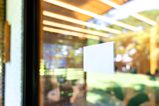 White rectangle are sticked on the glass door in front of seminar hall with blur bokeh background.