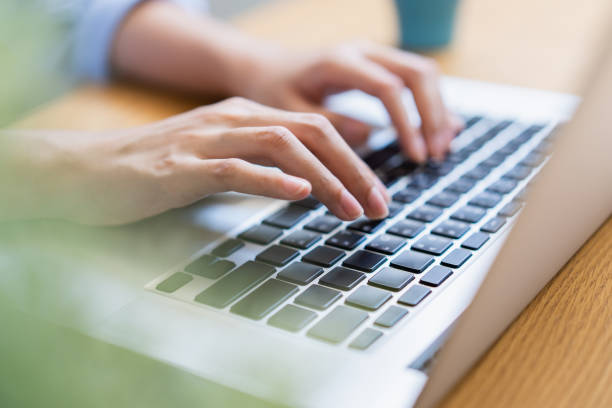 istock Close up female hand using laptop texting working from home. 1251074462
