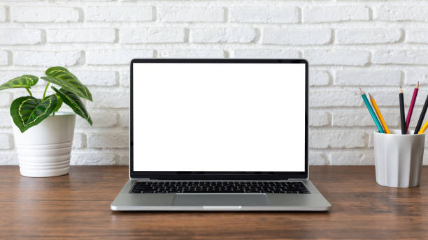 istock laptop computer with blank white screen, with workspace and office supplies on a wooden desk 1251075424