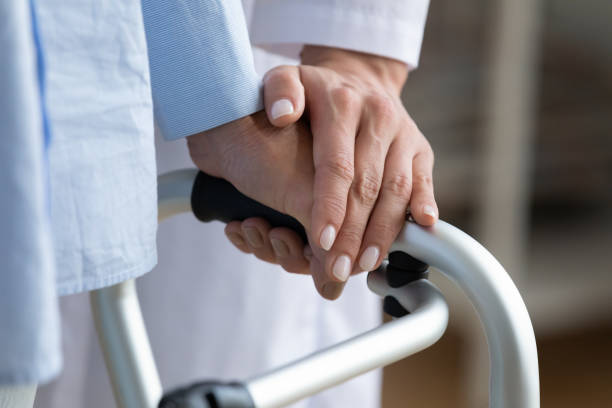 istock Physiotherapist touches woman hand while she holding walking frame closeup 1251077768