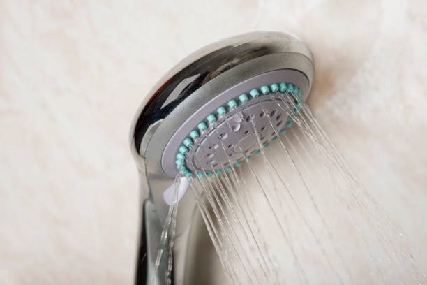 istock Shower head with running water  in a bathroom 1251077801
