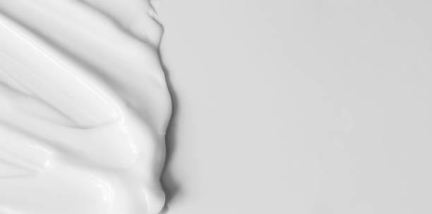 Close-up cream moisturiser smear smudge wavy texture on white background with copy space horizontal banner format. Skin care beauty product