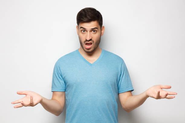 istock Young man with wtf face, spreading arms, isolated on gray background 1251099228