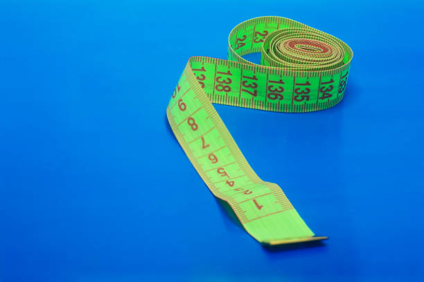 istock Green centimeter ribbon on a blue background. 1251100854