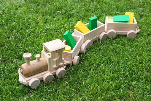 Children's wooden toys. Children wooden train with wagons. Natural wood construction set. Educational equipment. Children's wooden locomotive with various cargo in wagons.