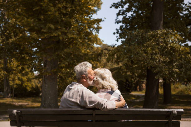 istock Happy senior couple sitting on a bench in park 1251106864