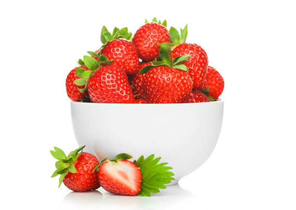 istock Fresh raw organic strawberries in white ceramic bowl plate on white background with berries next to it. 1251106963